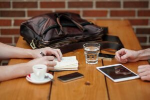 Personas trabajando en una mesa. En alusión a cómo se podría trabajar una mentoría.