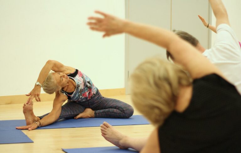 Aparecen dos mujeres adultas mayores haciendo yoga, como alusión al autocuidado, factor importante en el Día Internacional de Acción para la Salud de las Mujeres.